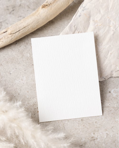 Preview: Blank card mockup on beige stone with driftwood and pampas grass top view, boho mockup