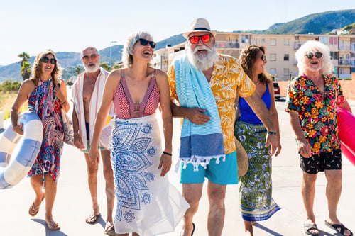 Preview: Happy group of senior friends bonding at the beach during summertime