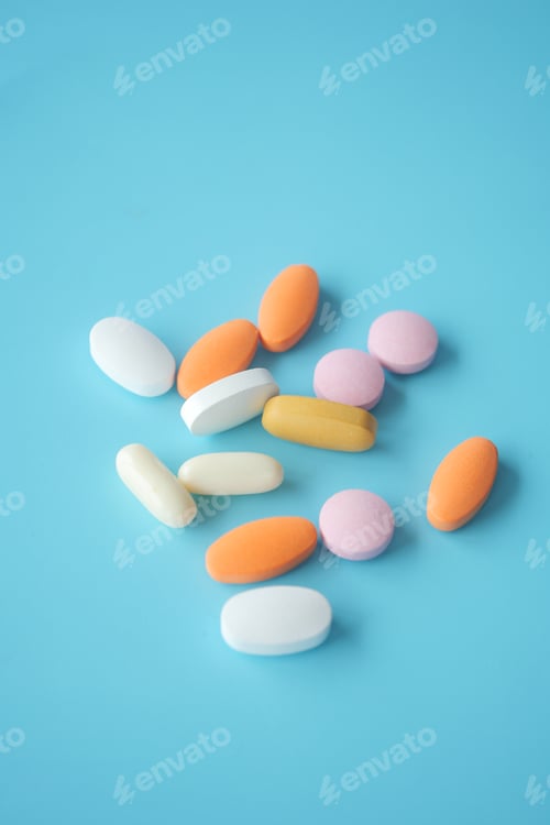 Preview: Colorful assortment of pills scattered on a blue background