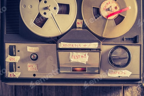 Preview: Retro reel-to-reel tape recorder and a used rolls of tape.