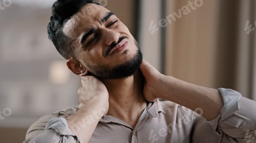 Preview: Tired hispanic exhausted man businessman employee suffering from muscles tension having painful neck