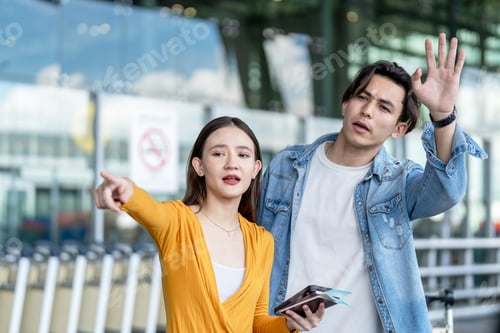 Preview: Asian couple passenger waiting public car outside airport terminal.