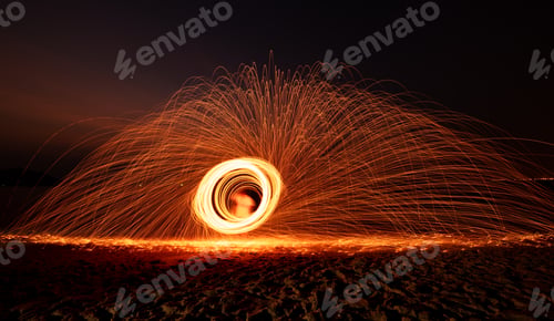 Preview: Fire dancer swing fire dancing show on celebration with dark sky background.