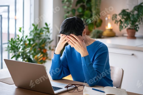 Preview: Overloaded tired mature woman with head in hands struggling with notes cause of depression, burnout