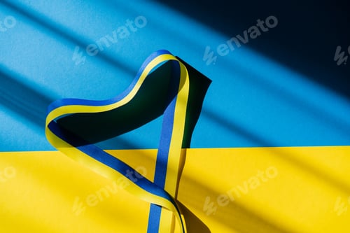 Preview: Top view of ribbon in heart shape with shadow on ukrainian flag