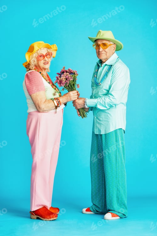 Preview: Beautiful senior old couple wearing fancy party clothes acting in studio on a colored background.