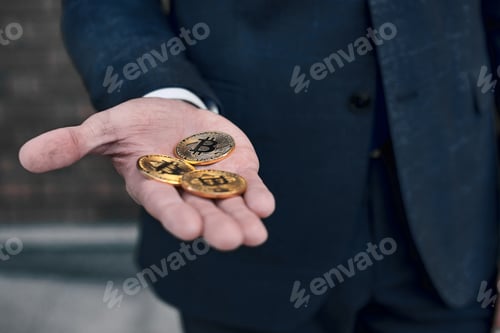 Preview: Gold coins bitcoin stacked in the palms hands of a young woman o