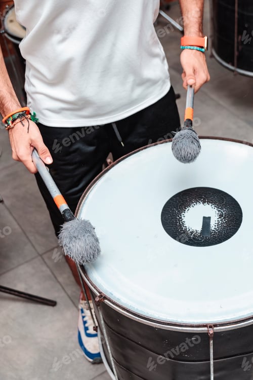Preview: Unrecognizable man playing a batucada drum with maces
