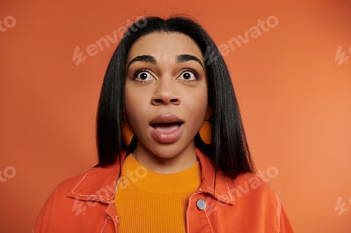 Preview: Surprised Expression of a Beautiful African American Woman Against an Orange Backdrop