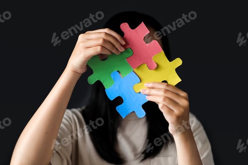 Preview: Woman Holding Puzzle Jigsaw Pieces as a Symbol of Autism Spectrum Disorder