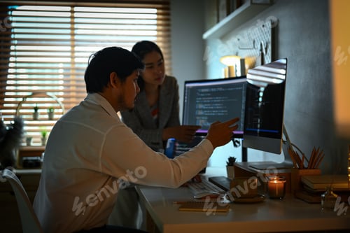 Preview: IT software developers team brainstorming and programming on desktop computer in dark room