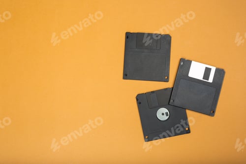 Preview: Old floppy disks on an orange surface in a simple layout