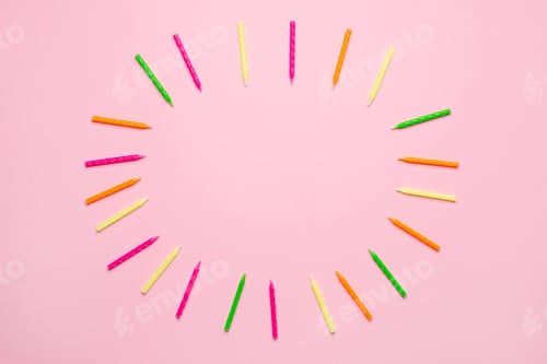 Preview: Colorful candles for birthday cake frame on a pink background with copyspace
