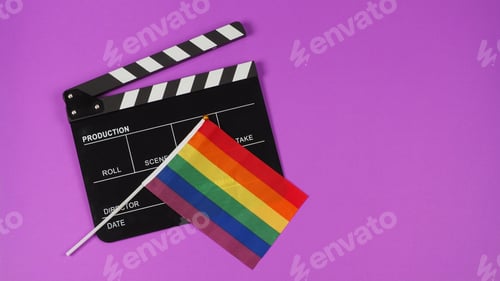 Preview: A rainbow flag and black clapperboard on purple background. LGBT CONCEPT.