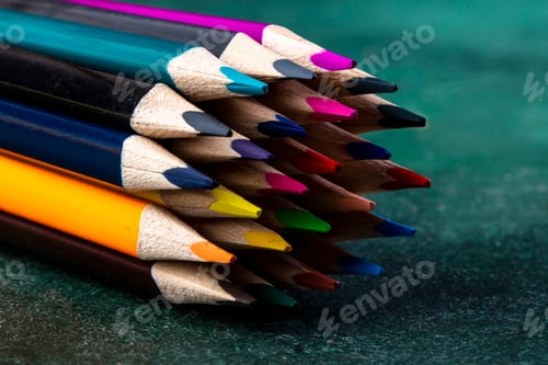 Preview: side view of a bunch of colored pencils on dark background