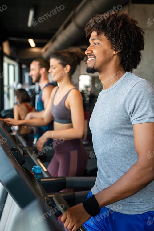 Preview: Group of young people running on treadmills in sport gym