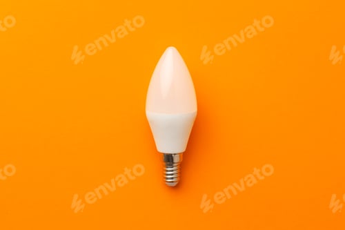 Preview: Light bulb on bright orange background top view