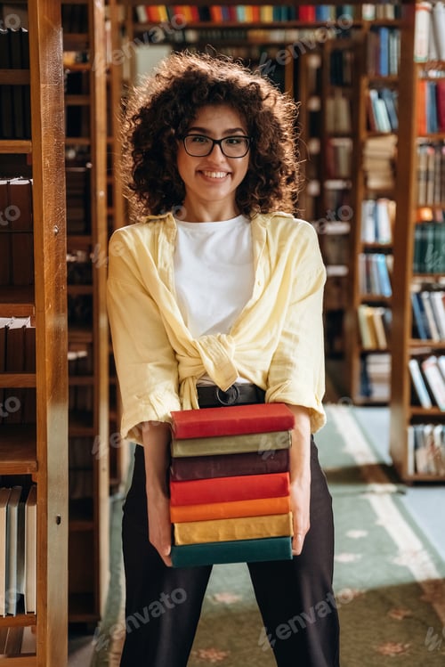 Preview: Standing and smiling. Beautiful woman is in the library