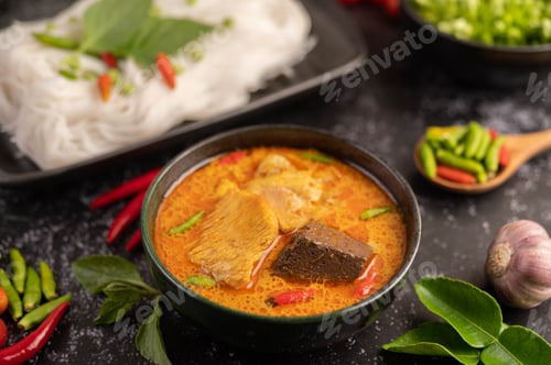 Preview: Chicken curry in a black cup with rice noodles.