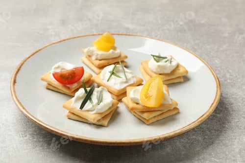 Preview: Tasty crackers with cream cheese, rosemary and tomatoes on grey textured table, closeup