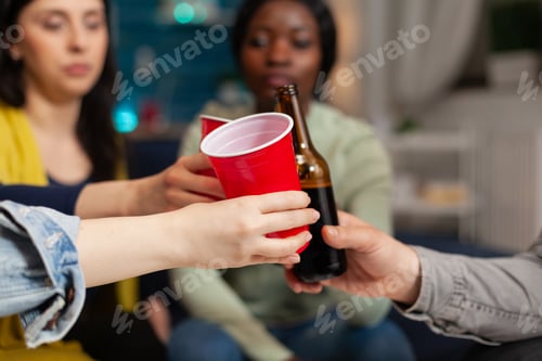 Preview: Multi ethnic friends hanging out sitting on couch chatting