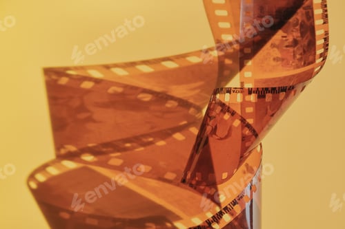 Preview: Film strip spiraling creating an abstract shape against warm background