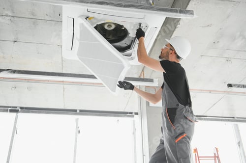 Preview: Worker repairing ceiling air conditioning unit