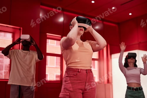Preview: Futuristic Young Women Wearing Vr Headsets in Red Room