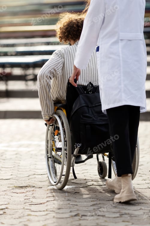 Preview: Rear view, nurse carrying a wheelchair with a patient.