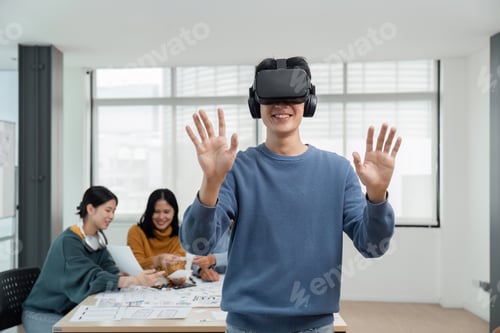 Preview: A cheerful and excited young Asian male developer tested a new VR game on a VR headset in the