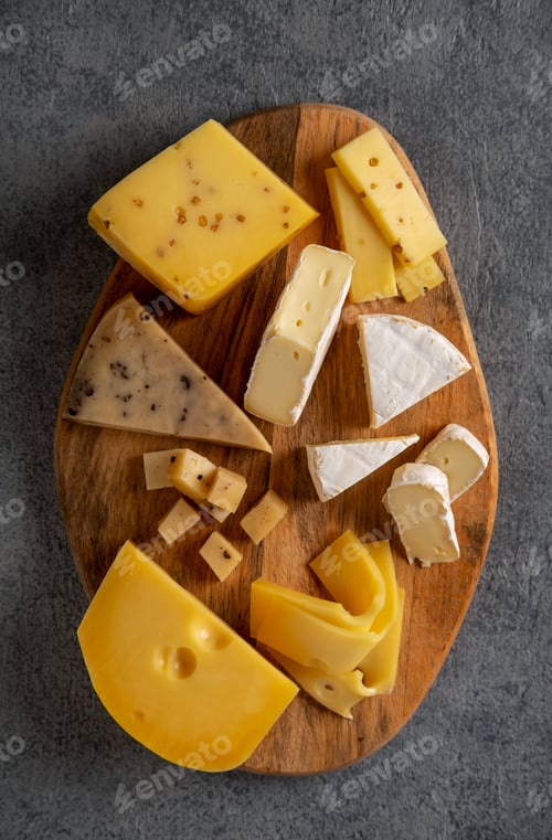 Preview: Cheese platter on wooden board. Cheese background. Closeup.