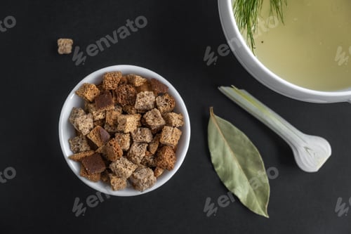 Preview: Homemade meat bone broth with dill and croutons and seasonings. A dietary dish. Close-up.