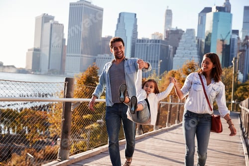 Preview: Young family with daughter taking a walk on footbridge
