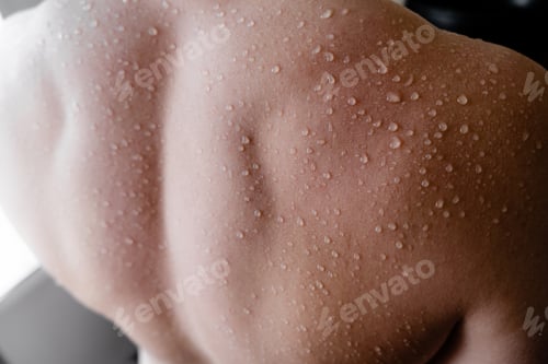 Preview: A caucasian young man's back with water drops