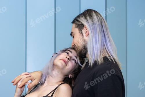 Preview: Woman embracing a man in a loving embrace, looking into his eyes against a blue background