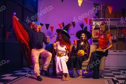 Asian friends, middle-aged man and young woman, enjoy Halloween office party with vampire costumes