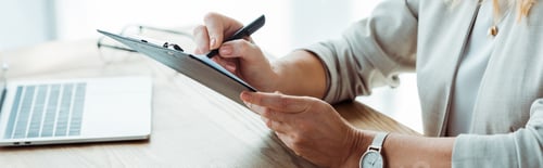 Preview: panoramic shot of recruiter writing on clipboard in office