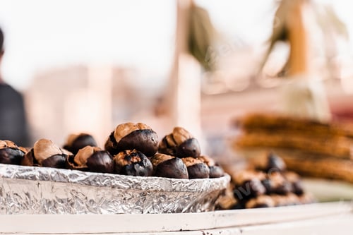 Preview: Roasted chestnuts on pan, street market snack grilled to perfection