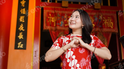 Preview: Asian Chinese woman in a cheongsam dress with congratulations gest at vihara