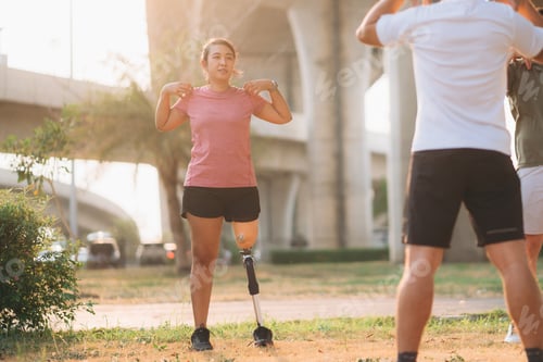 Preview: Woman exercising in a park with a friend providing support while using a prosthetic leg.