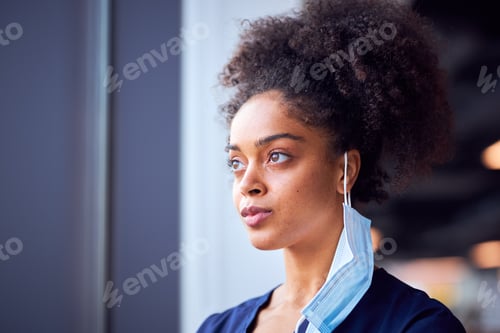 Preview: Female Doctor With Face Mask Wearing Scrubs Under Pressure In Busy Hospital During Health Pandemic