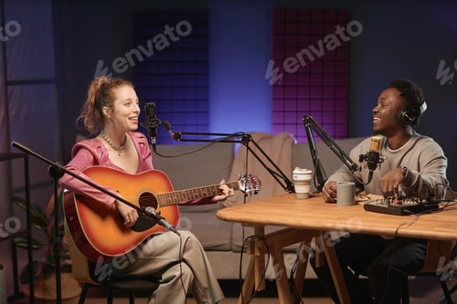 Preview: Cheerful Male Host and Female Guitarist in Podcast Studio