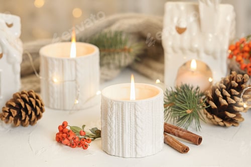 Preview: Holders with burning candles and decoration on white table against blurred Christmas lights