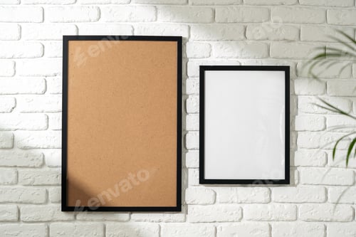 Preview: Two Empty Picture Frames Hanging on a White Brick Wall With a Plant in the Foreground