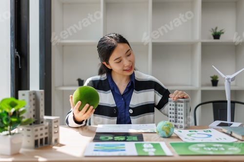 Preview: Woman holding a green natural sphere and building model, planning for esg future