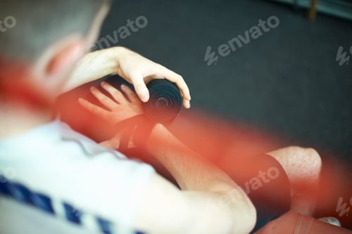Preview: Boxer bandaging hands before putting on gloves, rear view