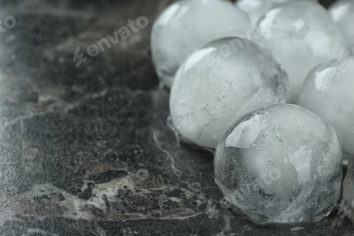 Preview: Many frozen ice balls on black marble table, closeup. Space for text