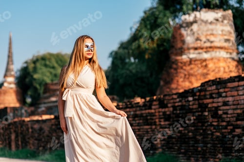Preview: Design your summer. Outdoor portrait of sexy girl in white dress and carnival mask.