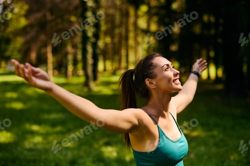 Preview: Carefree woman enjoying in sunlight with her arms outstretched.