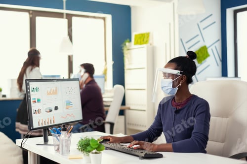 Preview: African woman at workplace working on computer